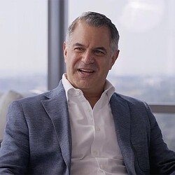 A man in a suit smiling.