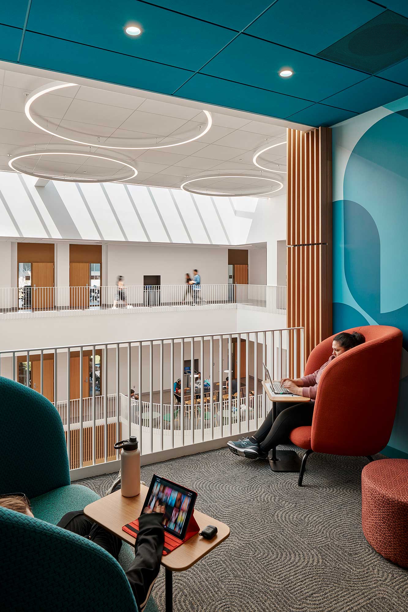 A room with a large glass wall and a table with chairs and a laptop on it.