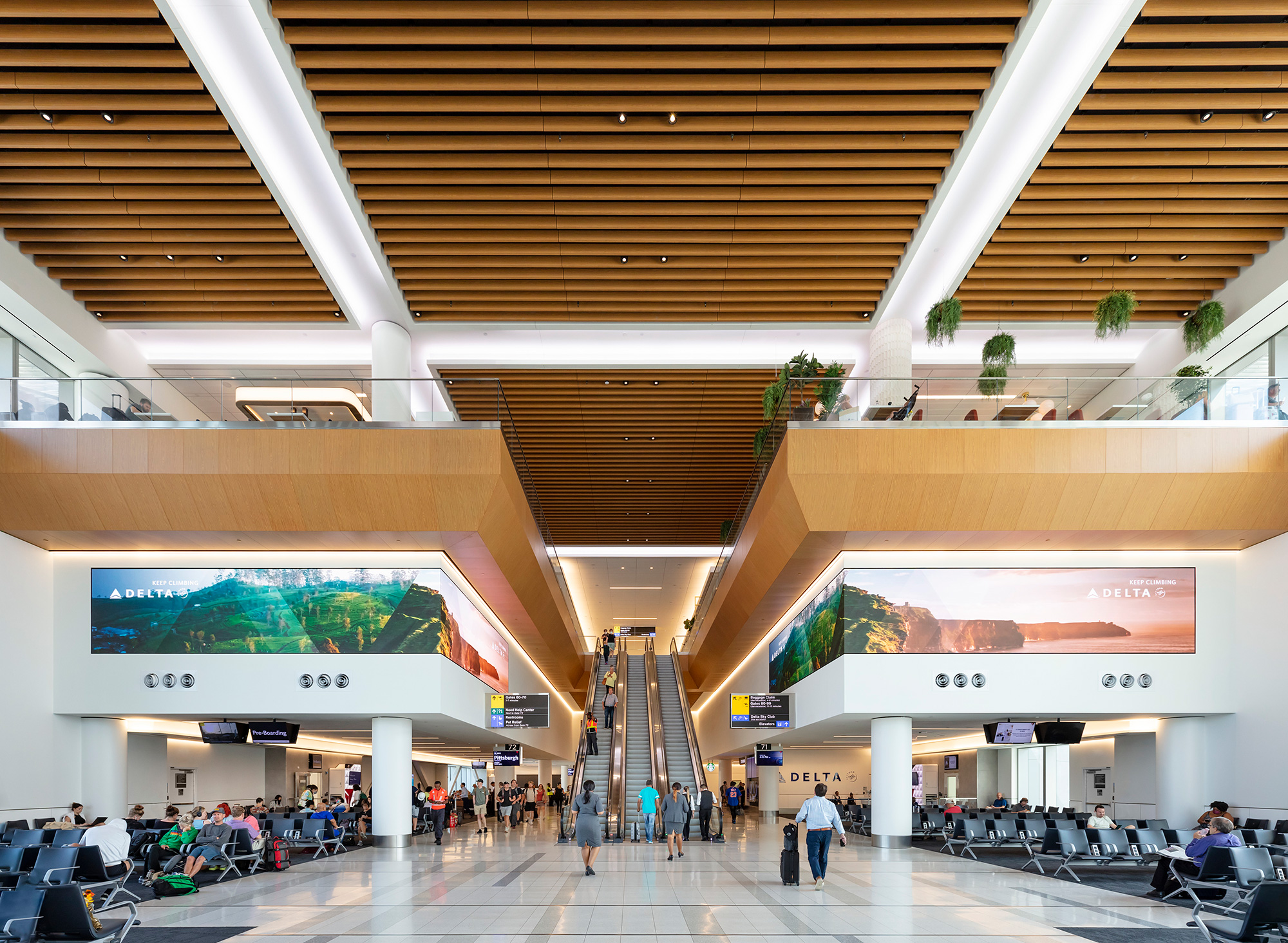 A large building with a large screen and people walking around.