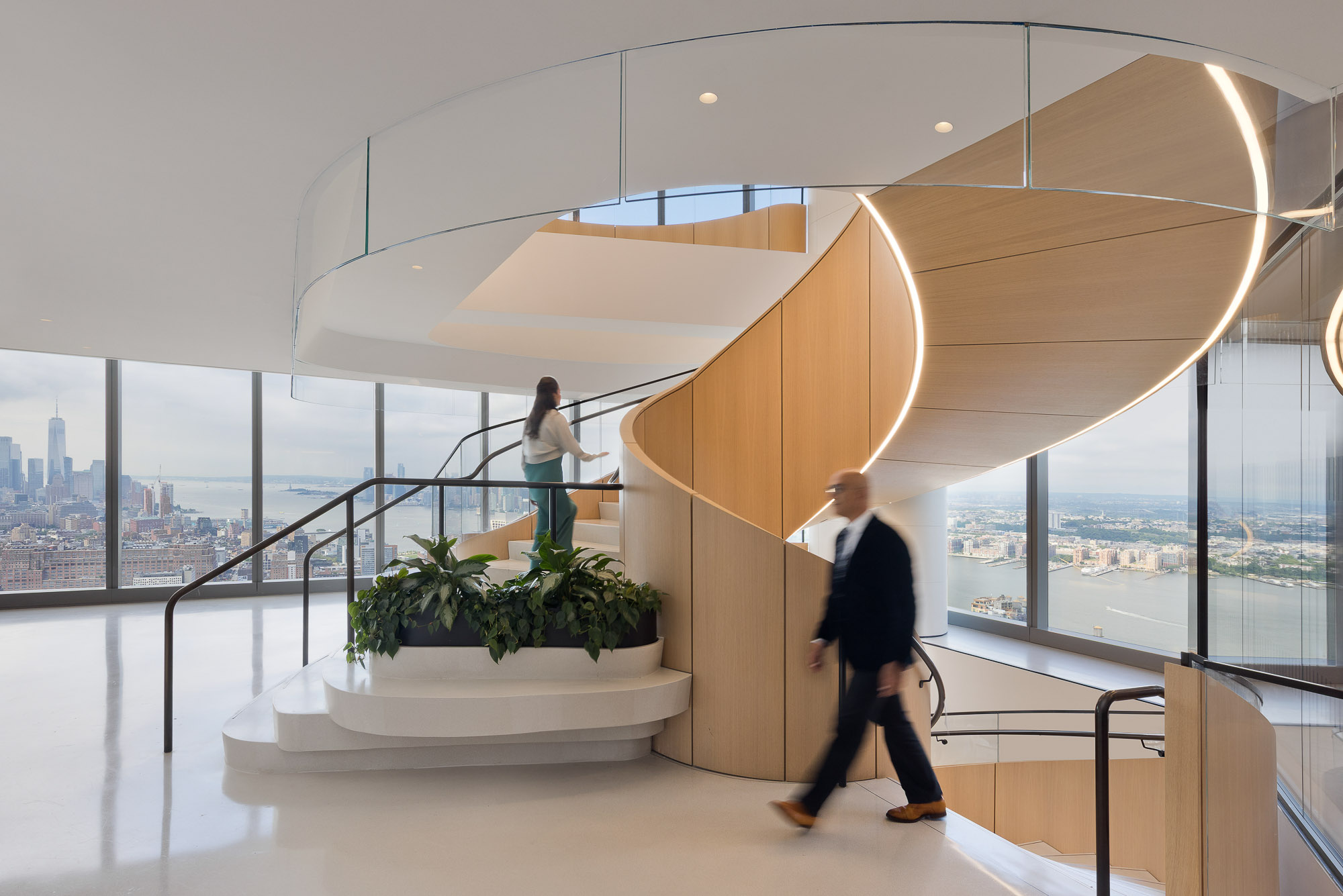 A man and woman walking down a staircase in a building.