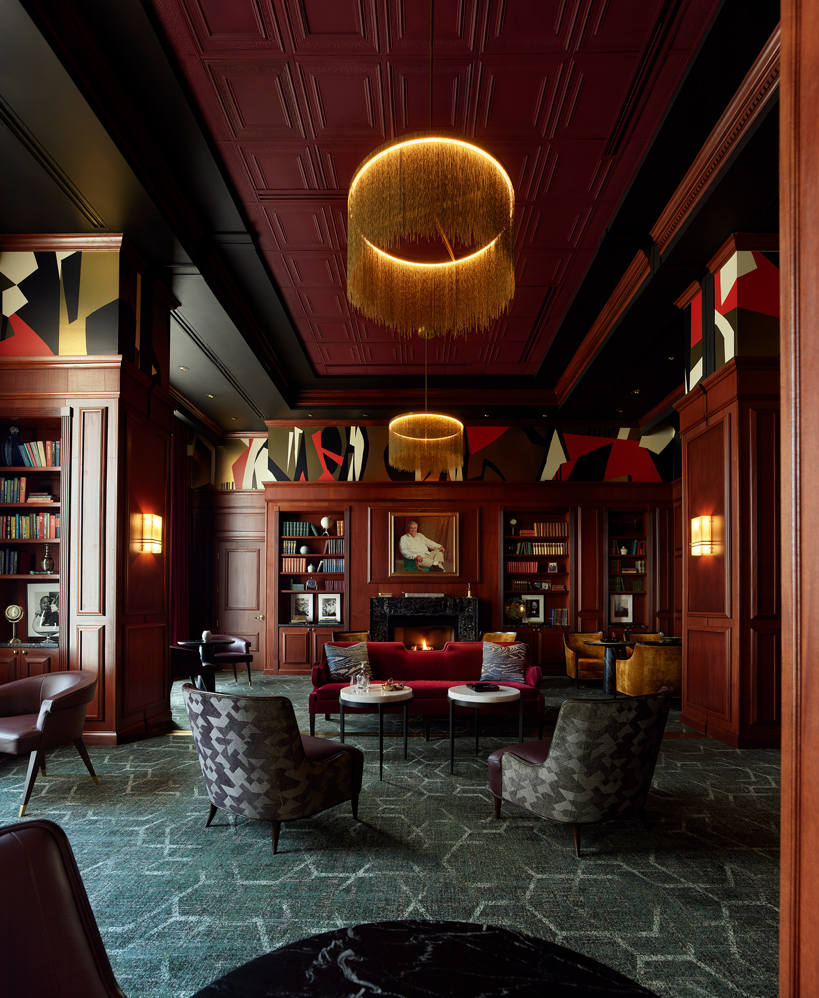 A room with a chandelier and chairs.