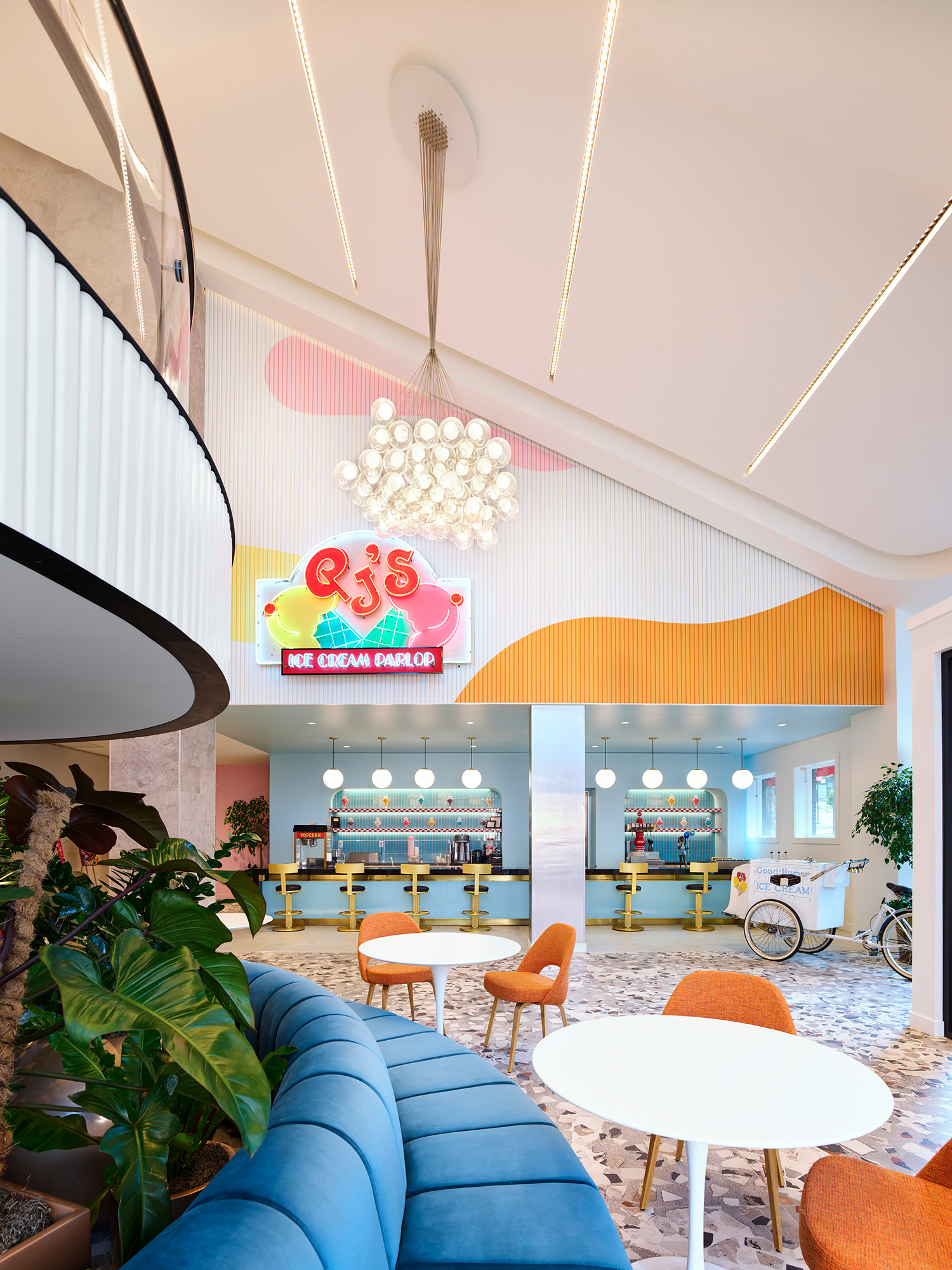 A room with a chandelier and chairs and tables.