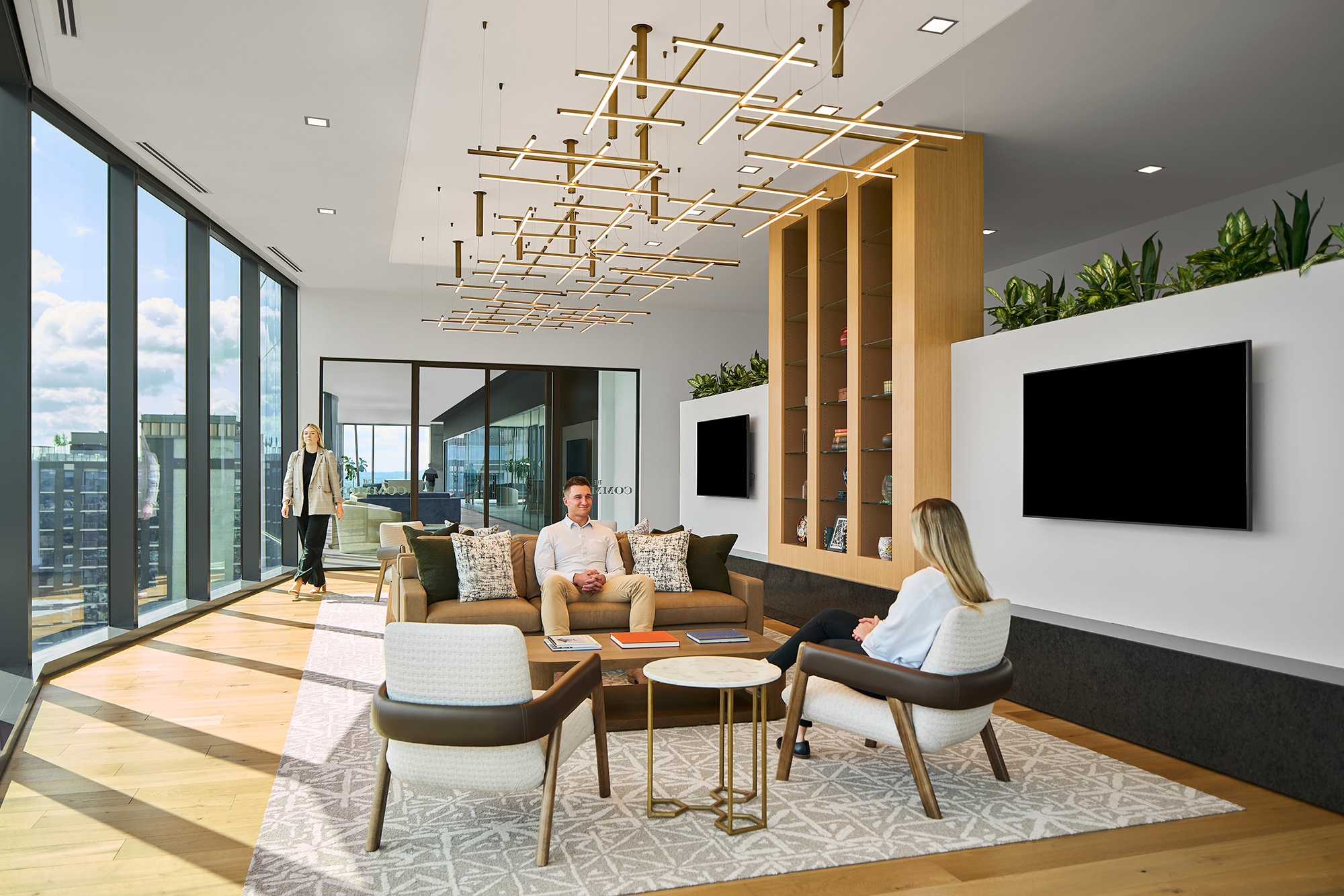 A man and woman in a living room with a chandelier.