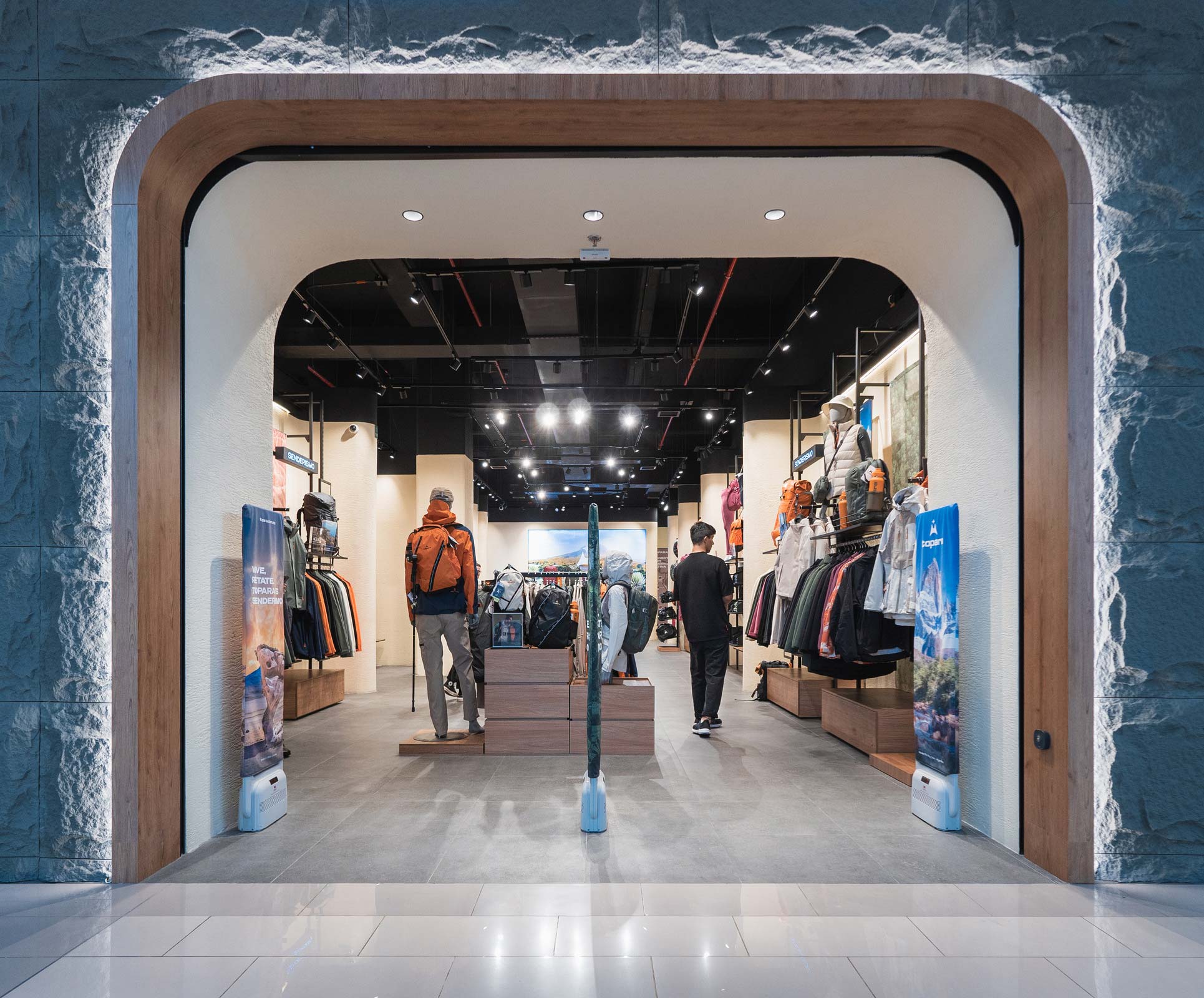 A couple of men walking through a store.