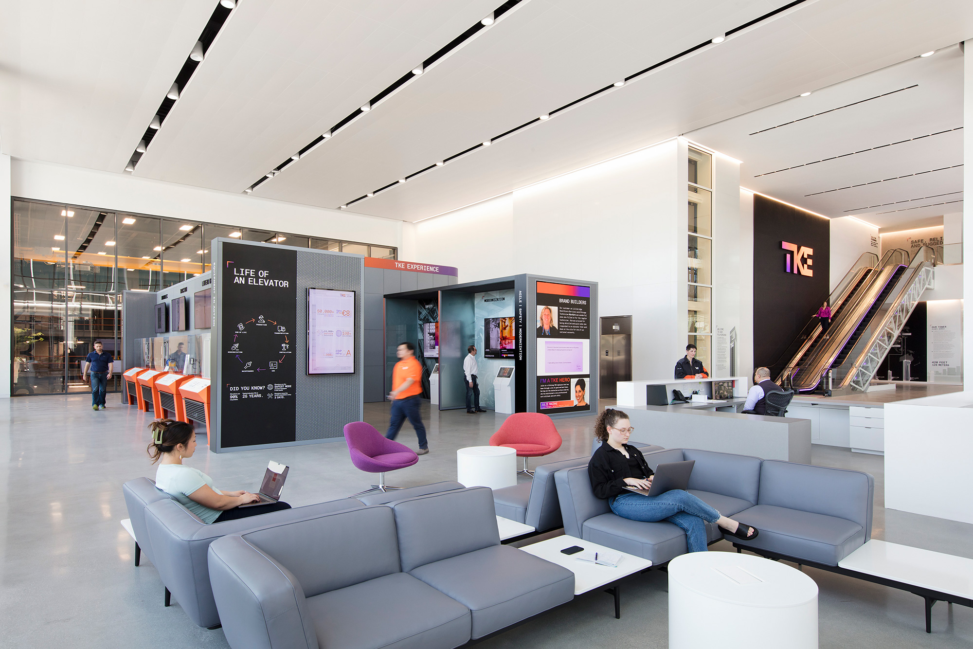 People sitting on couches in a room with a large screen.