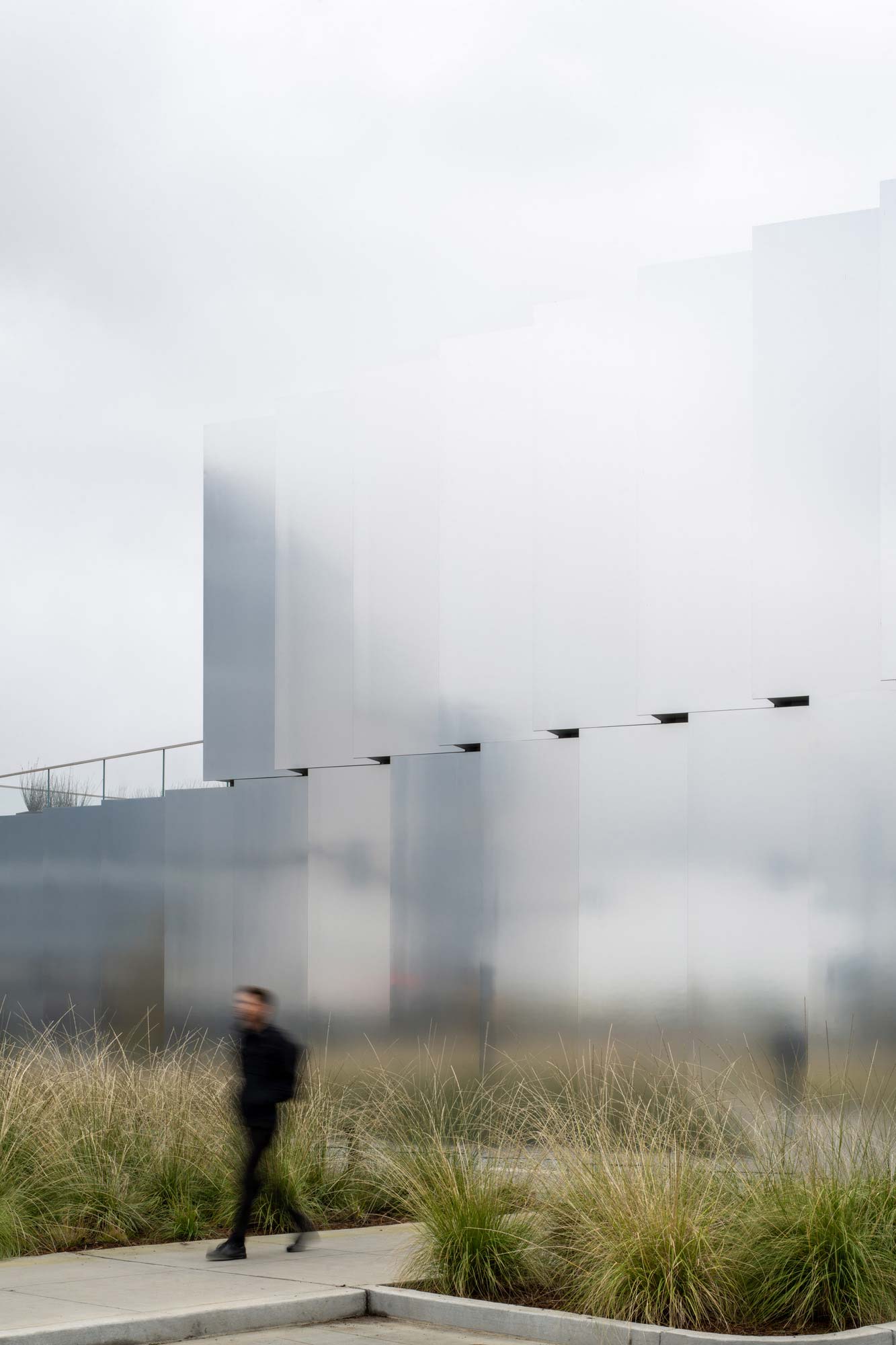 A man standing in front of a large building.