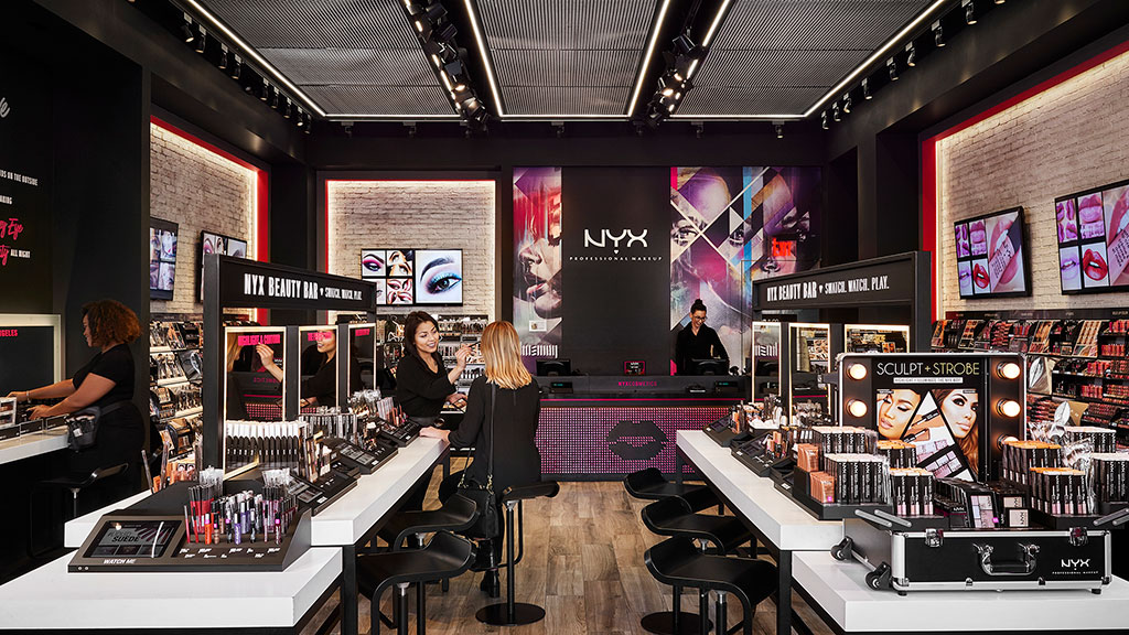 A group of people in a room with large screens.