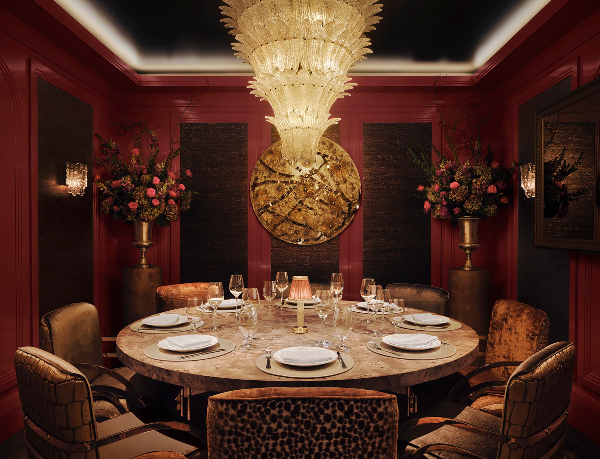 A dining room table with plates and glasses on it.