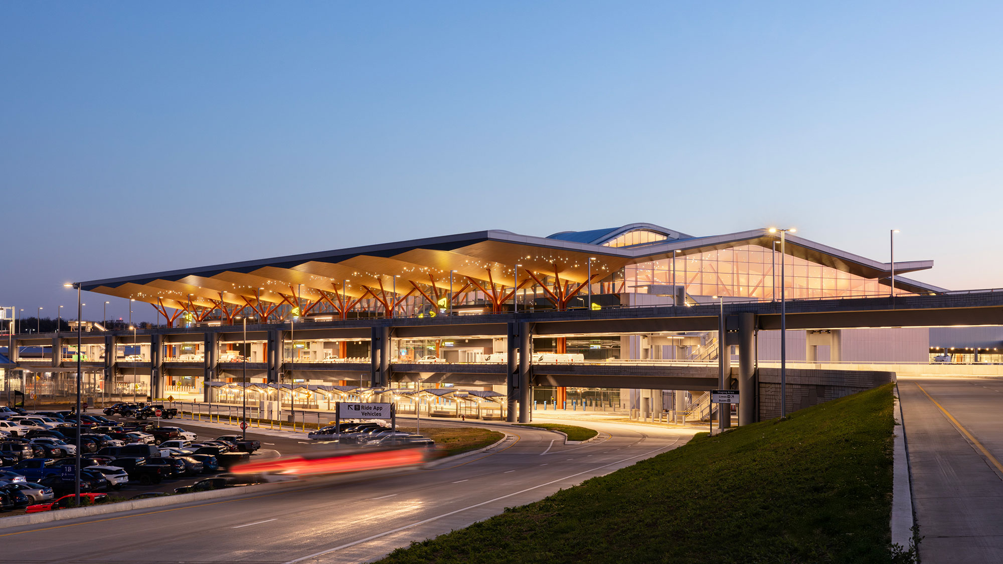 A large stadium with a field in front of it.