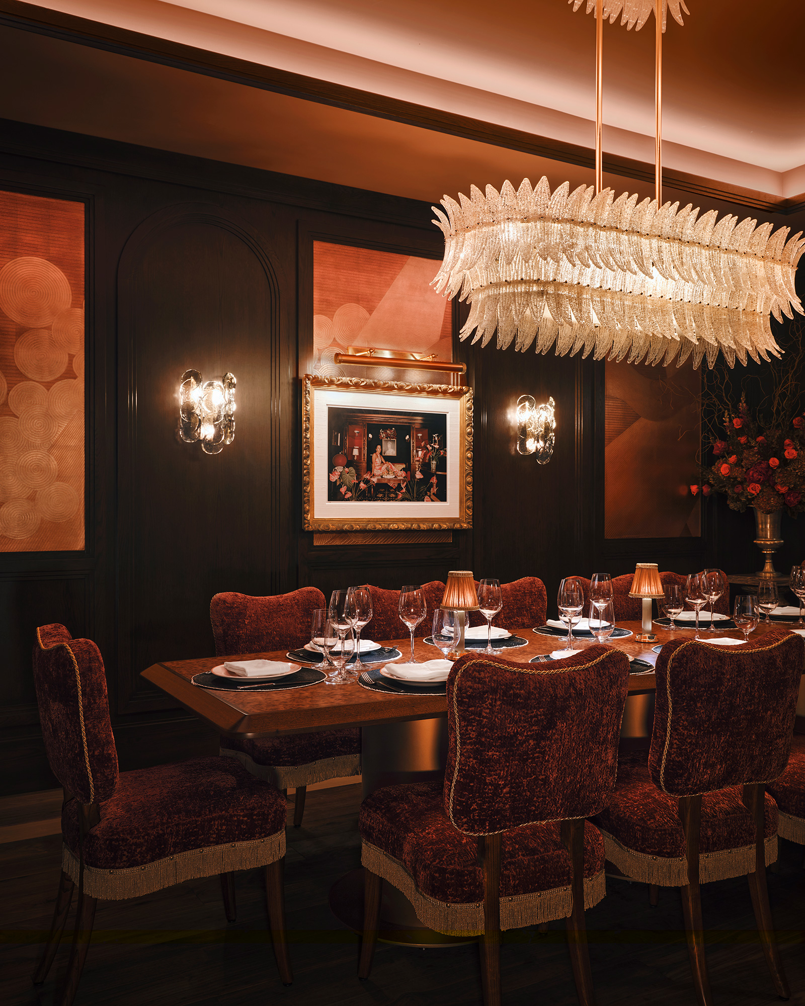 A dining room table with a chandelier above it.