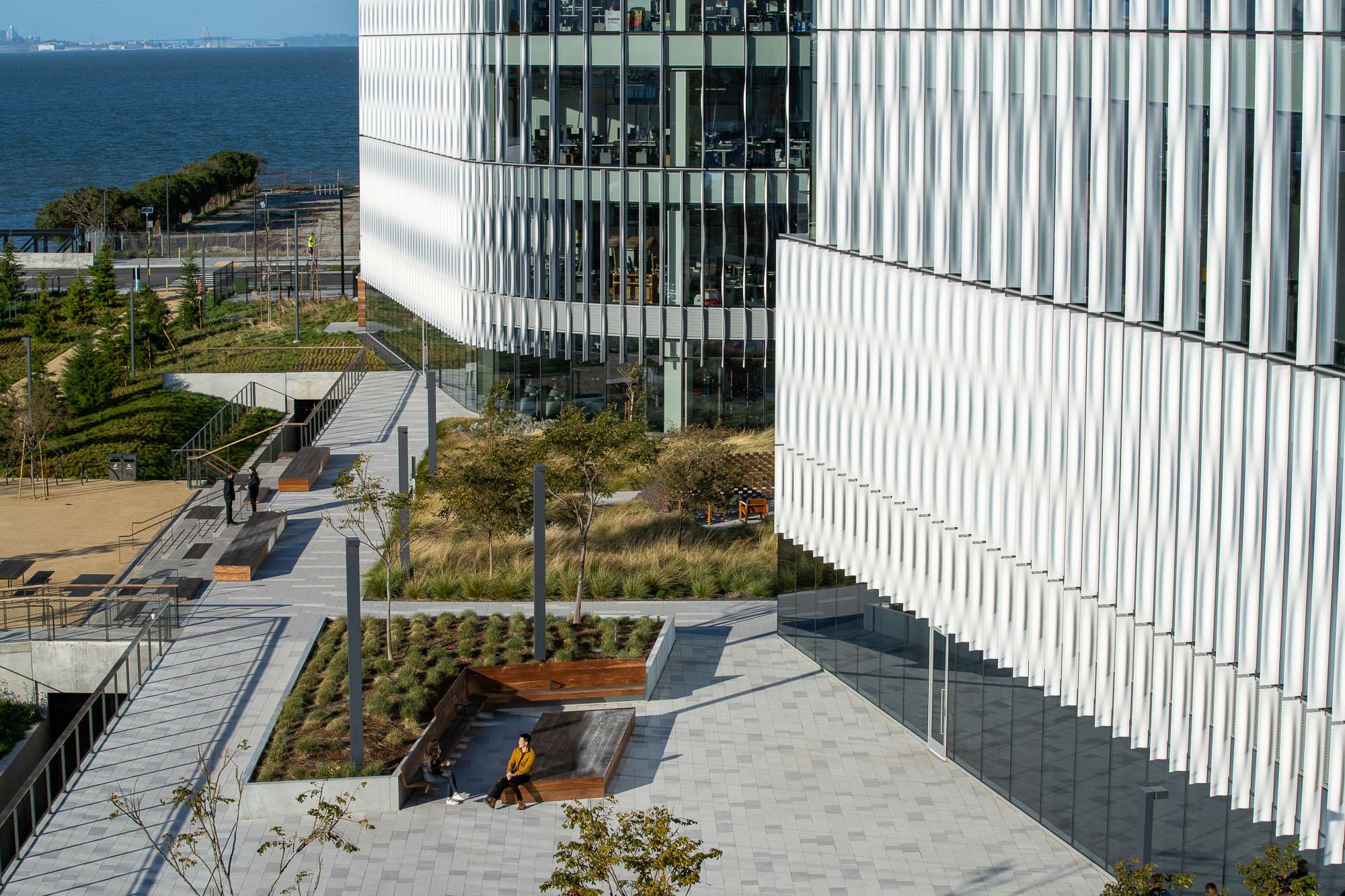 A building with a pool and a patio with a view of the ocean.