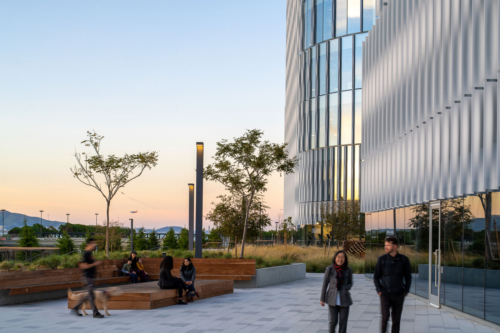 People sitting on benches outside a building.