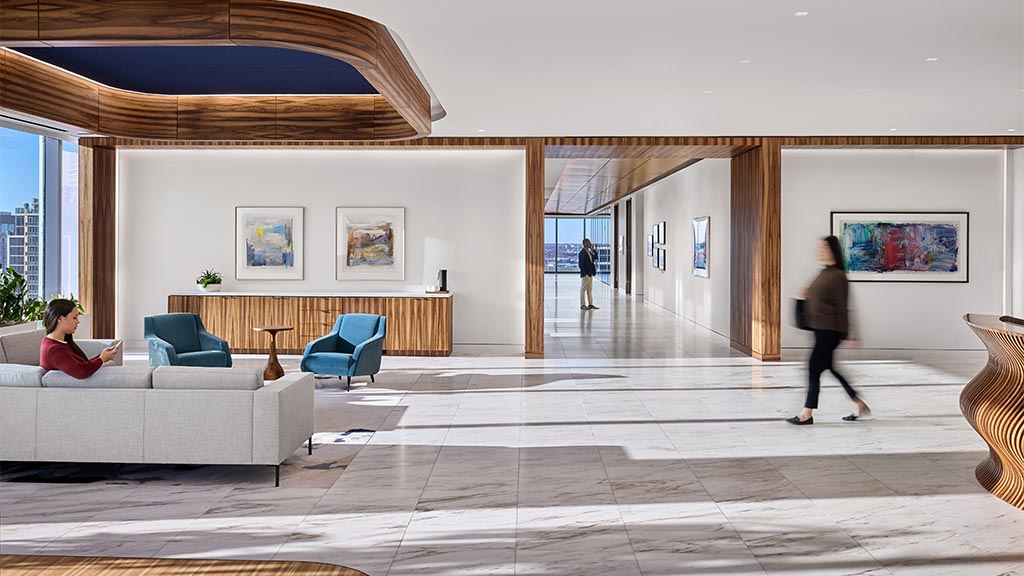 A woman sitting on a couch in a room with a man standing.