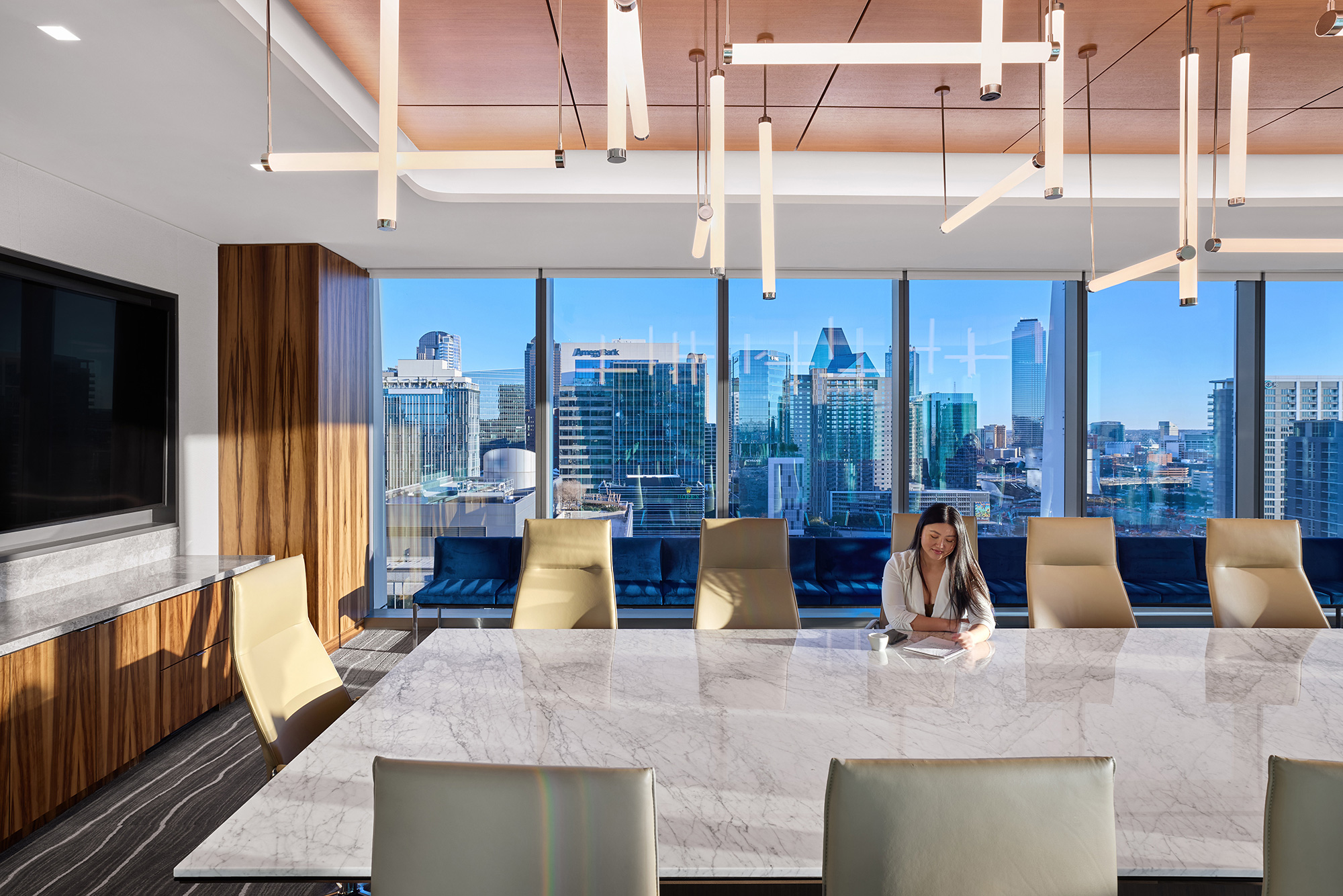 A person sitting at a table in a room with a large window.