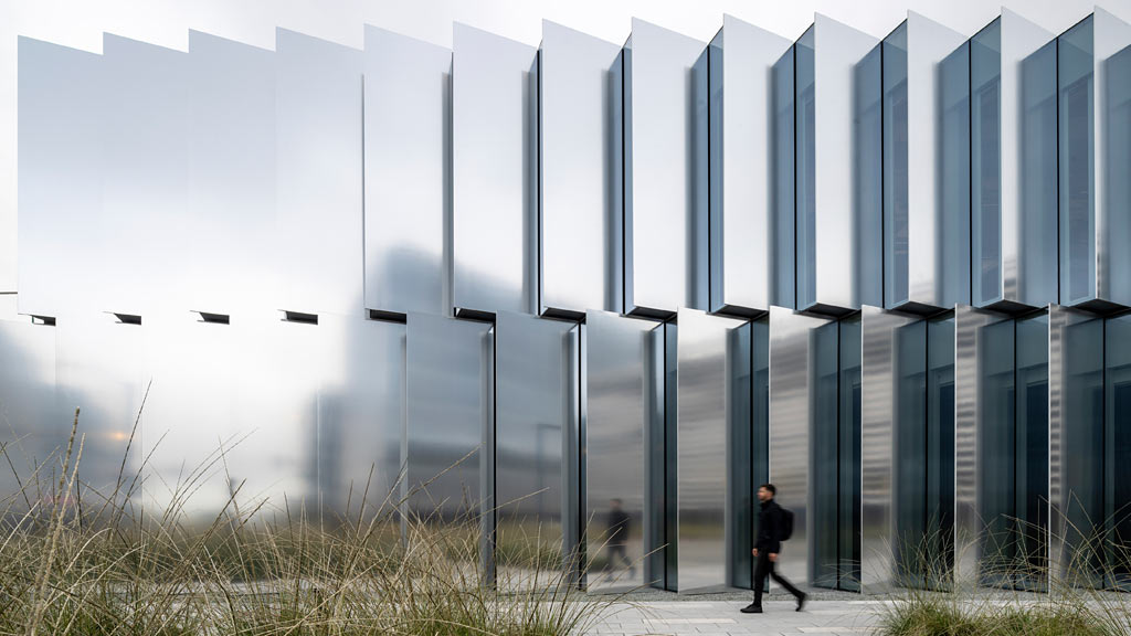 A person walking in front of a large building.