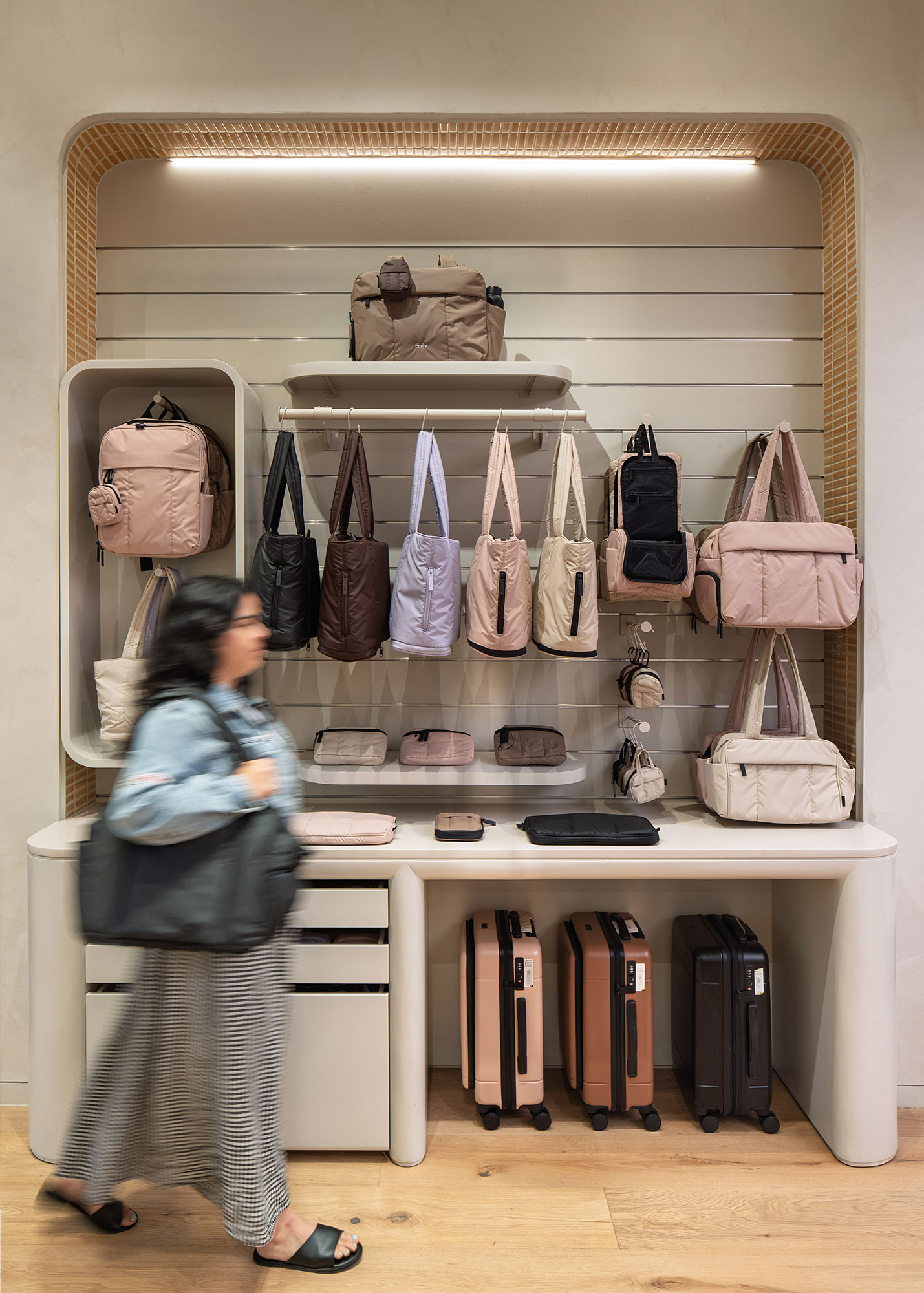 A person looking at a display of purses.