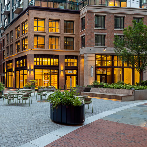 A courtyard with tables and chairs in front of a building.