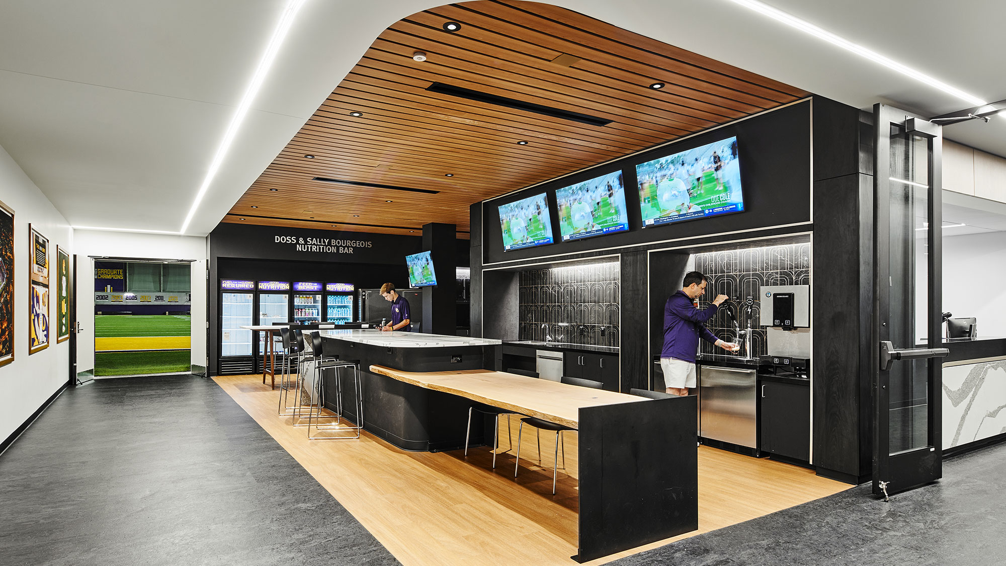 A few people in a room with large screens.