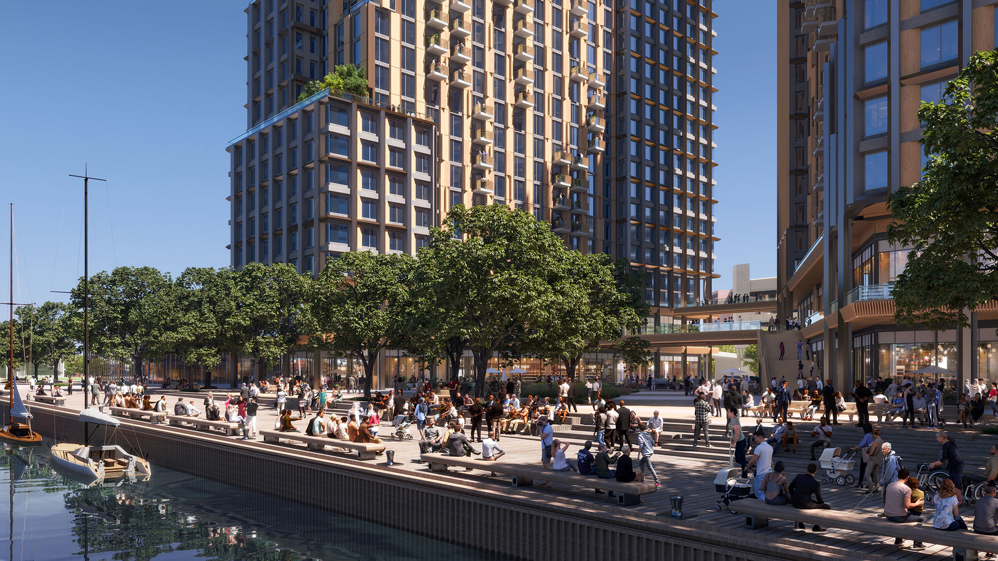 A group of people sitting on a bench by a river and buildings.