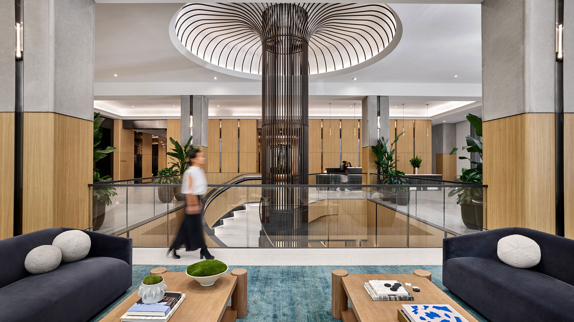 A couple of people walking in a room with a glass ceiling.