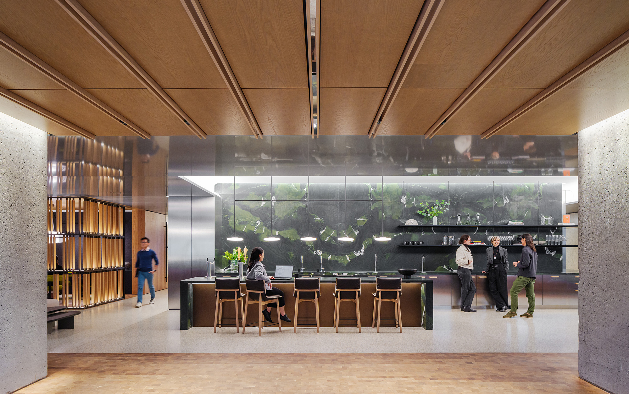 A group of people standing in front of a large screen.