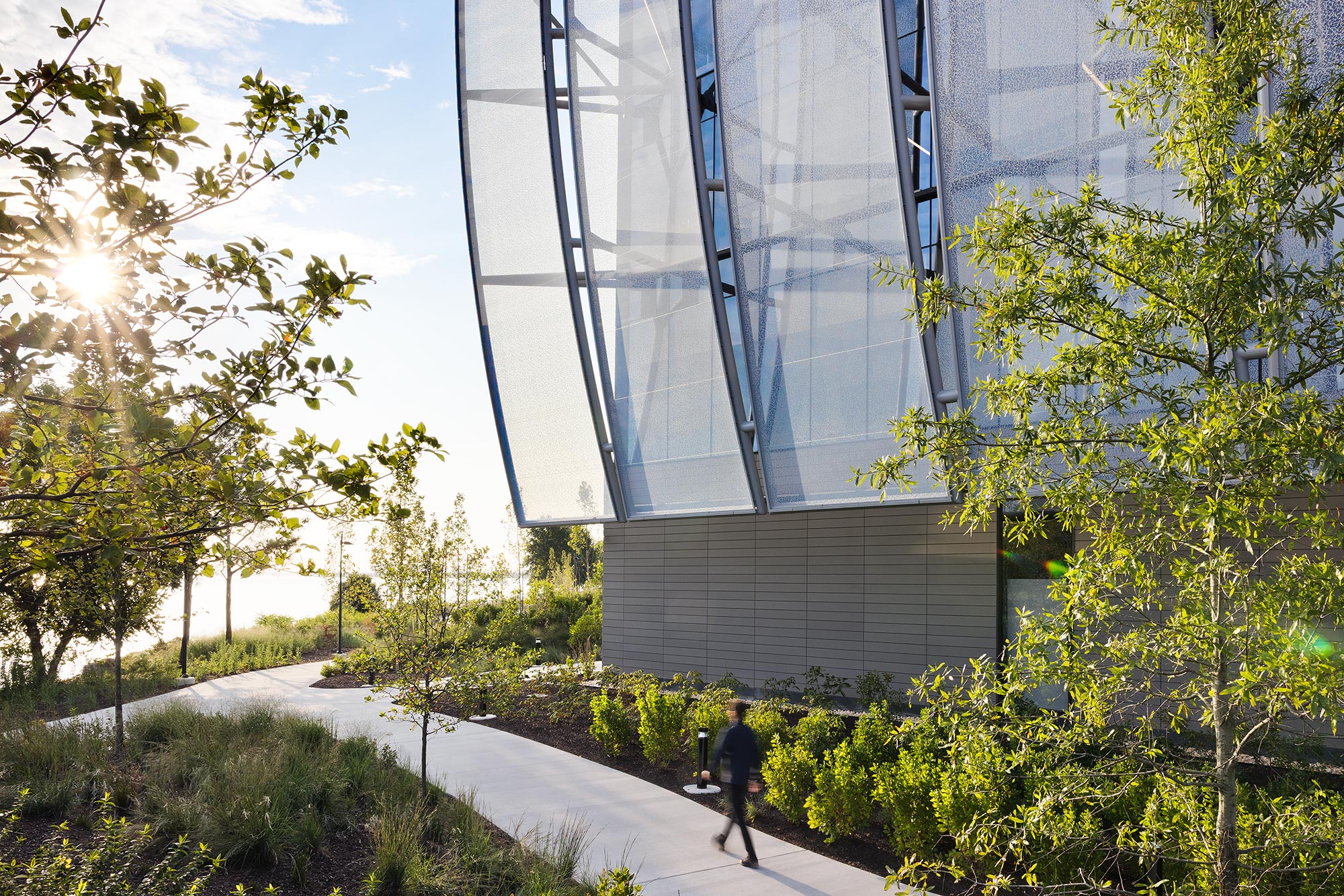 A person walking on a path next to a building.