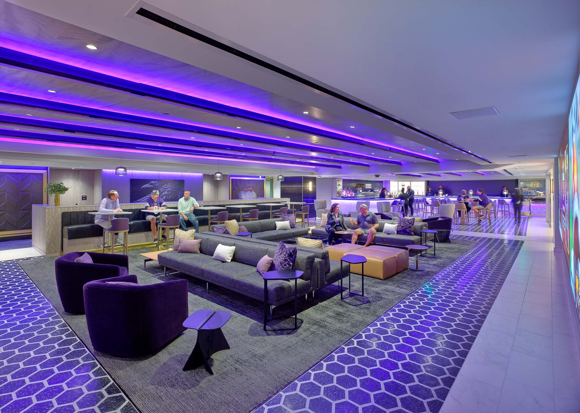 A room with purple couches and people in it.