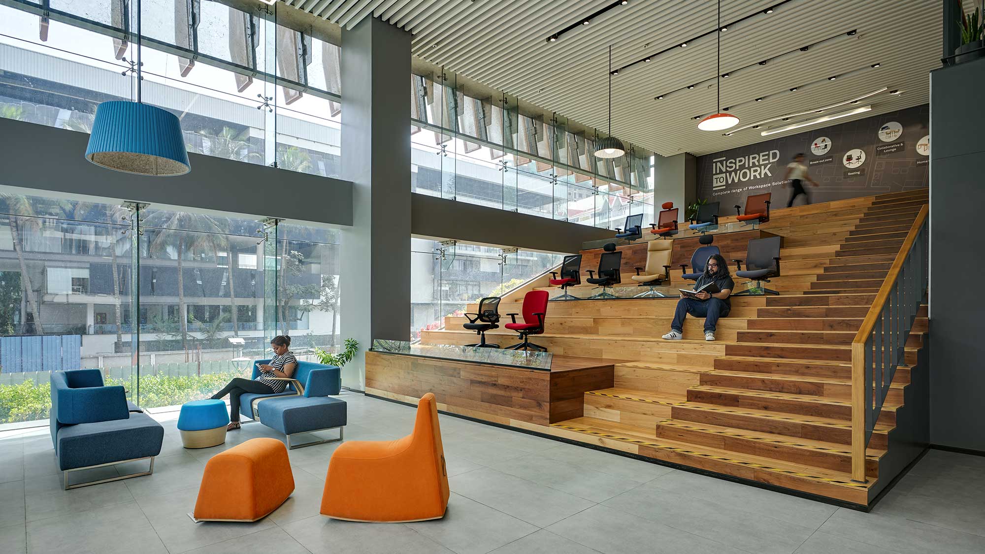 A group of people sitting on chairs in a room with windows.
