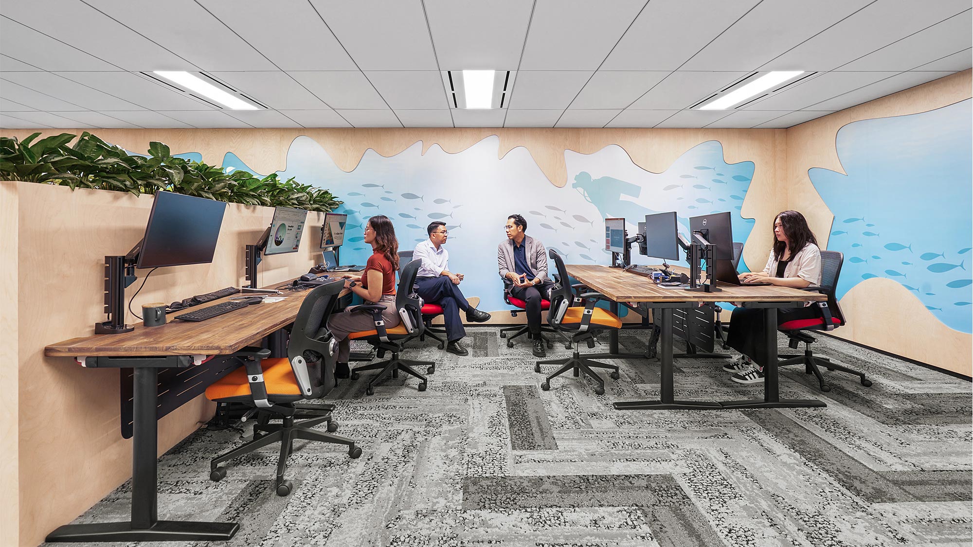 A group of people sitting around a table with computers.