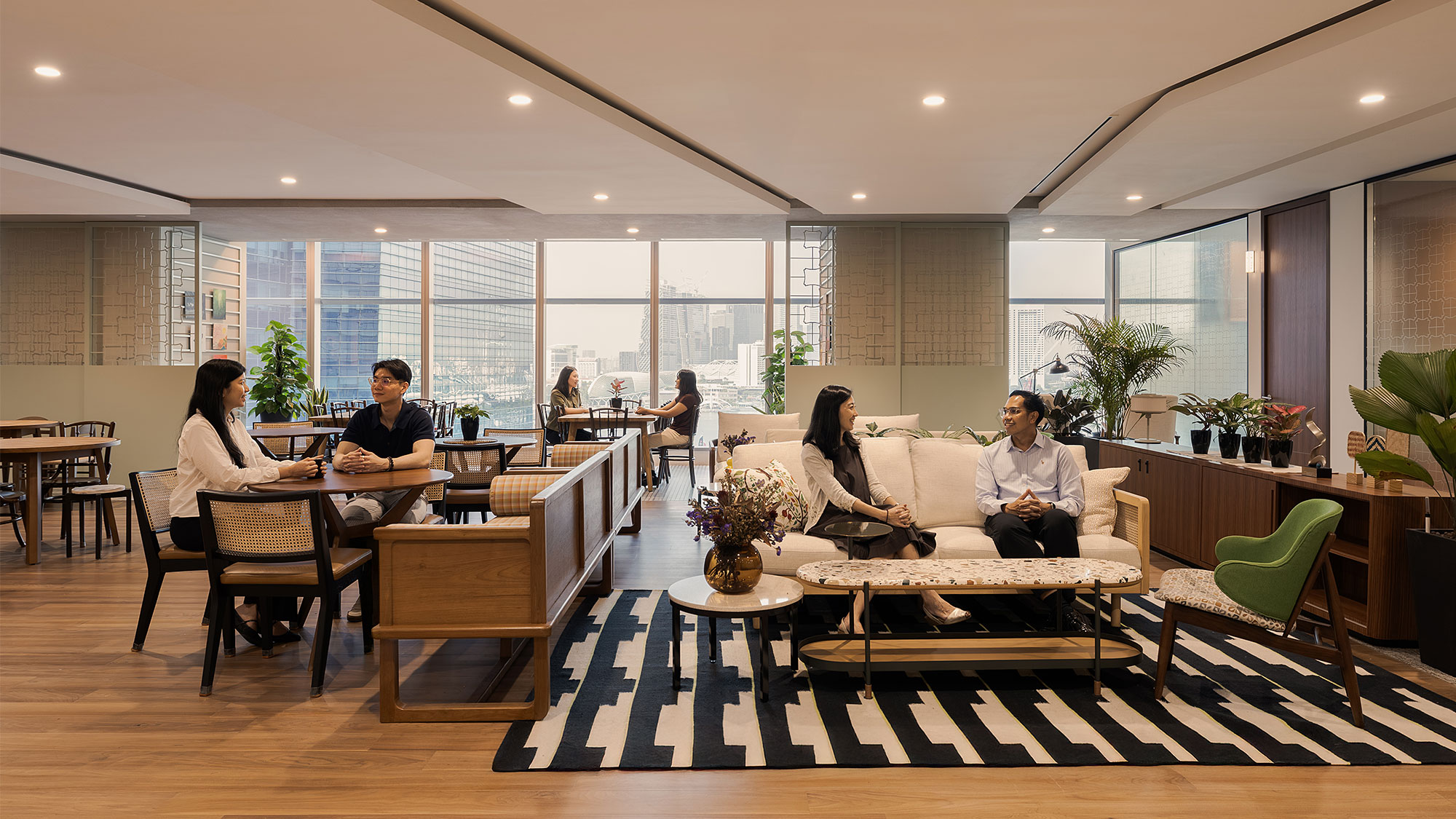 A group of people sitting in a room with a large window.
