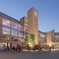 A group of people walking around a large building.