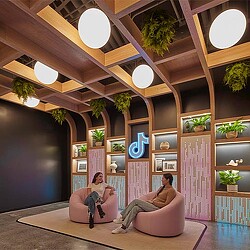 A man and woman sitting on a bench in a room with lights.