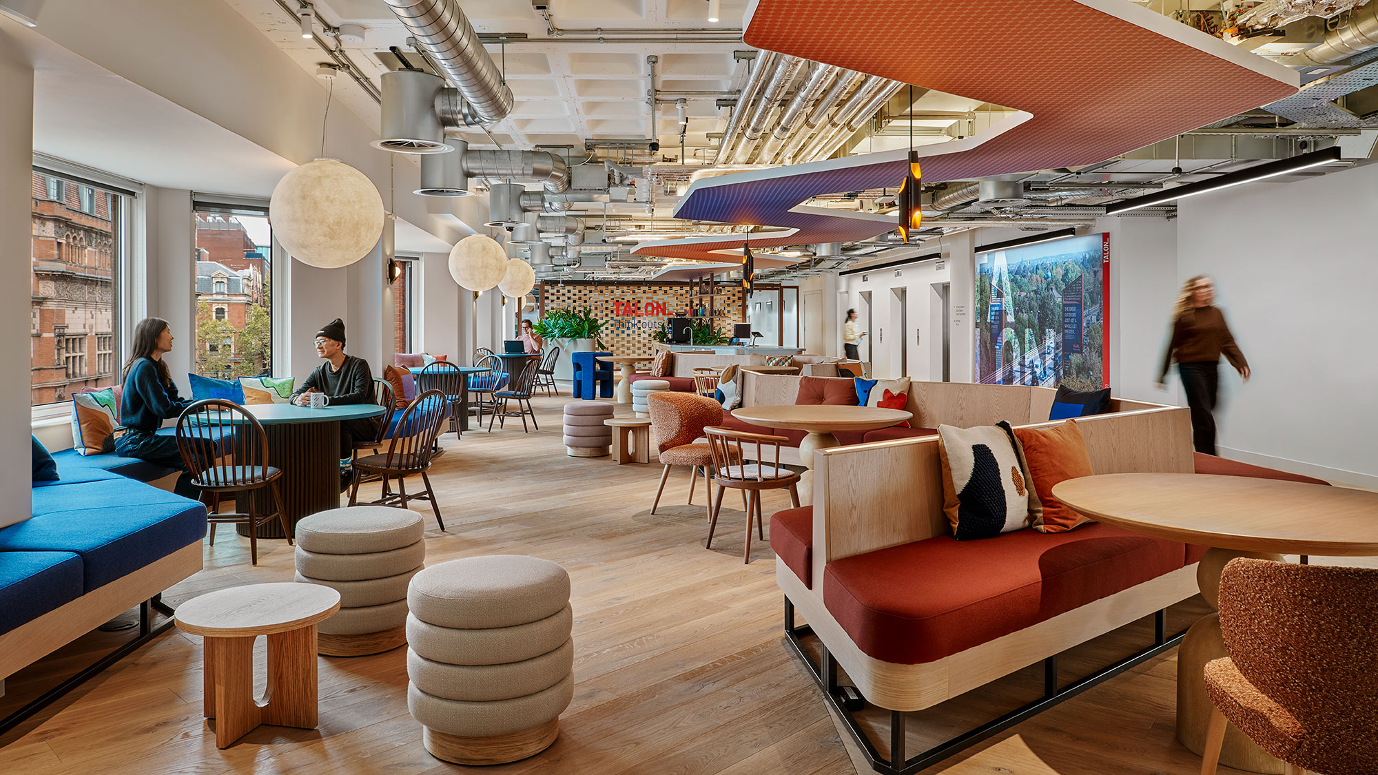 A room with a few people and a couch and chairs.