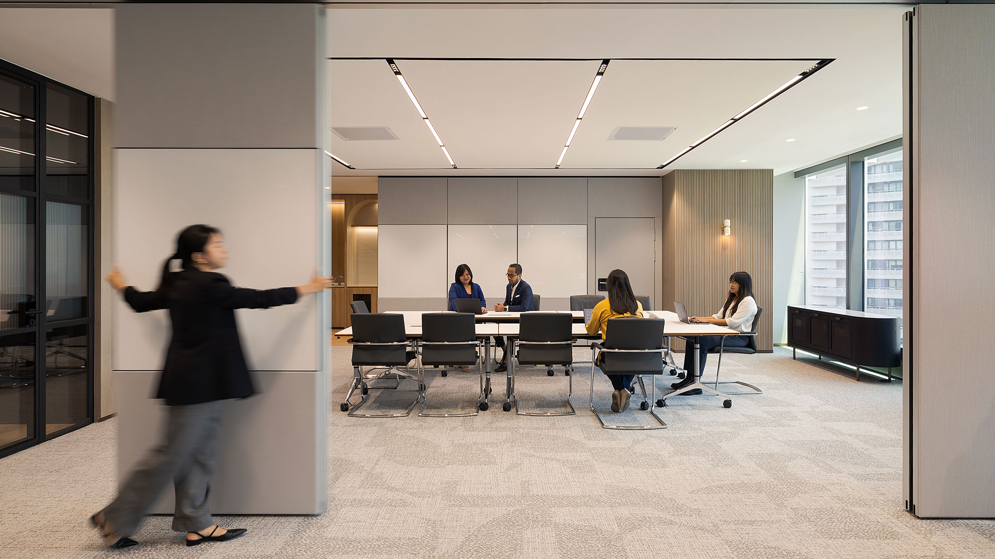 A person standing in a room with people sitting at tables.