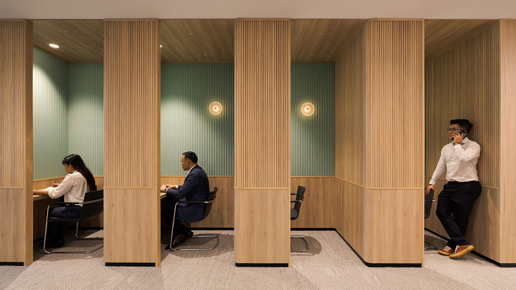 A man and a woman in a room with a green wall.
