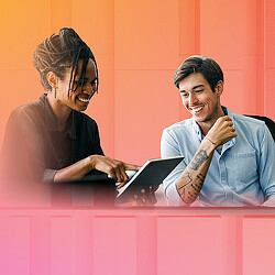 A man and a woman looking at a tablet.