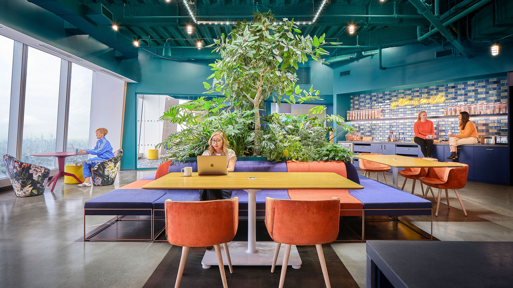 A group of people sitting at a table in a room with colorful tables.