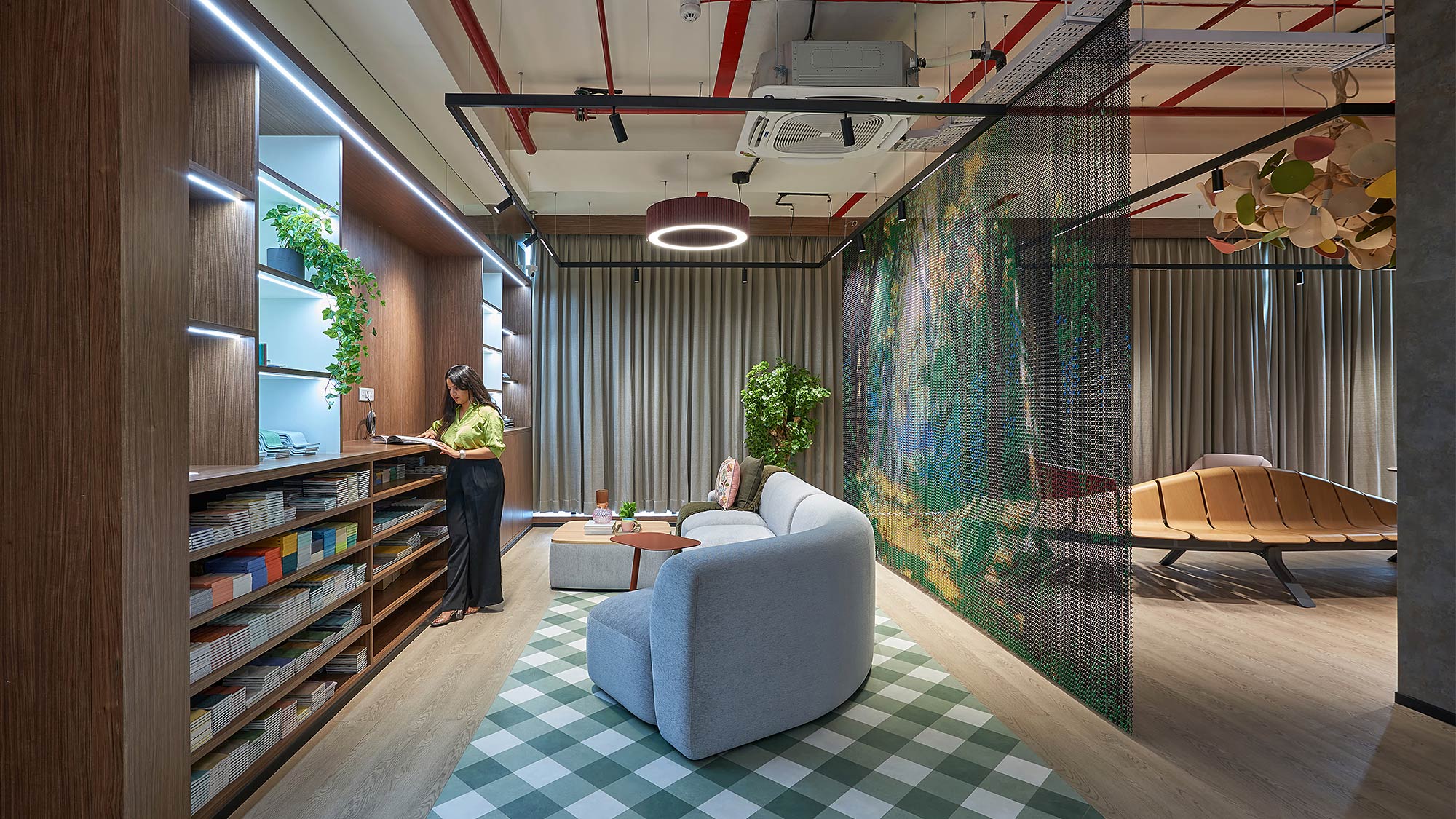 A person standing in a room with a couch and shelves.