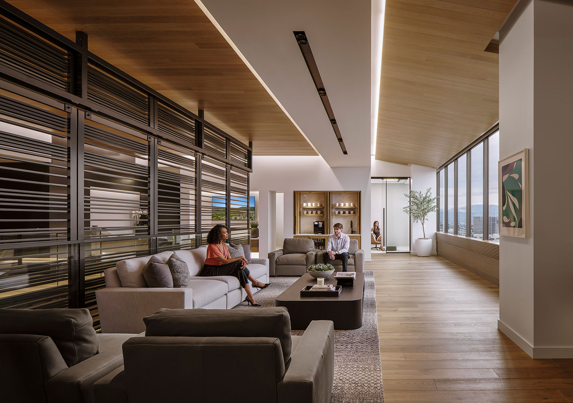 A couple of people sitting on a couch in a living room.