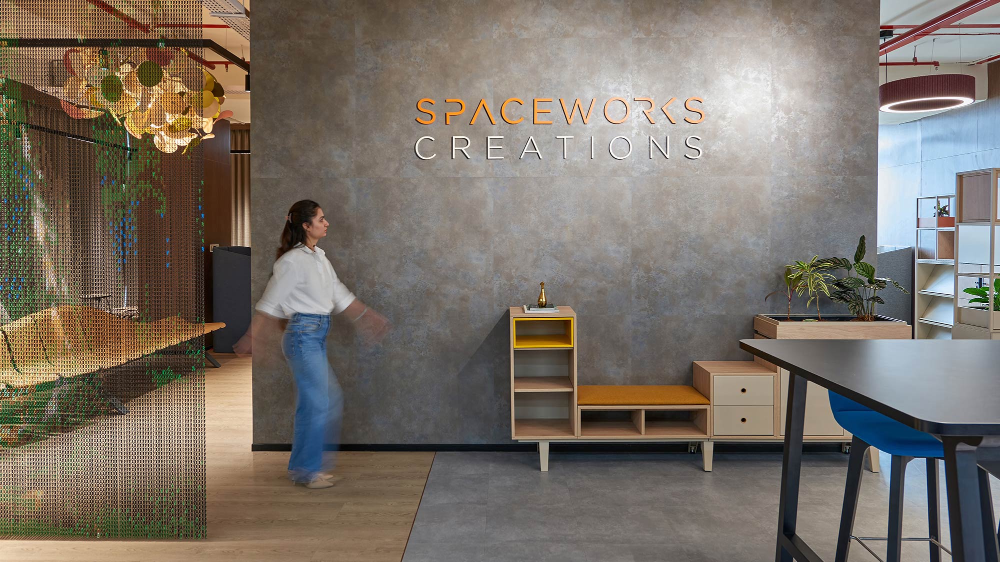 A person standing in front of a wall with a sign on it.