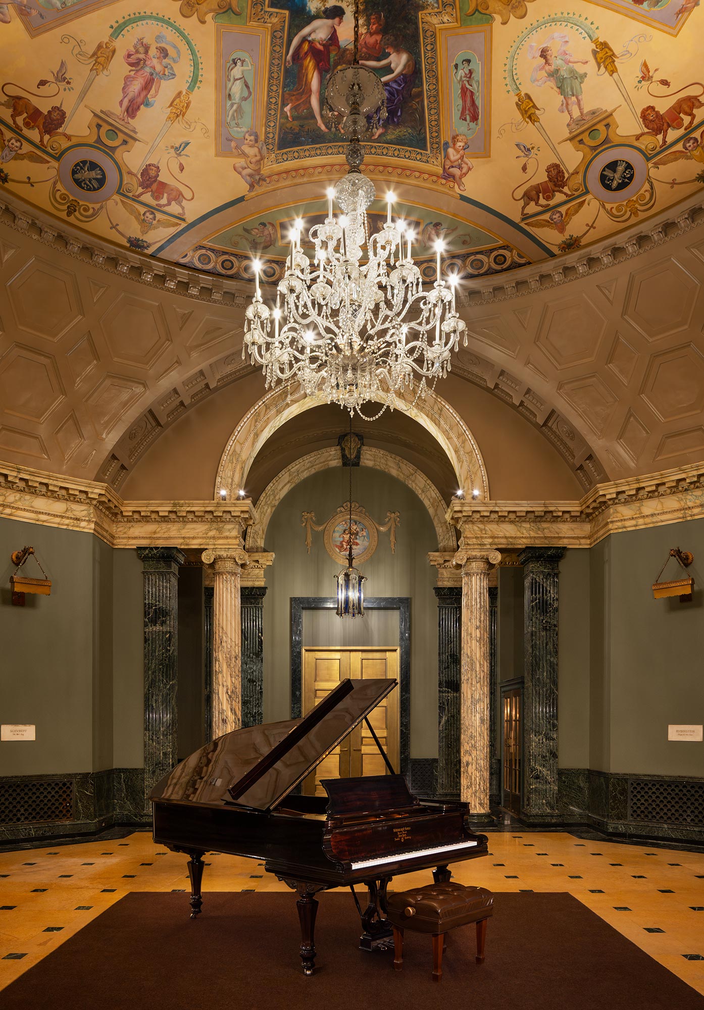 A piano in a room with paintings on the wall.