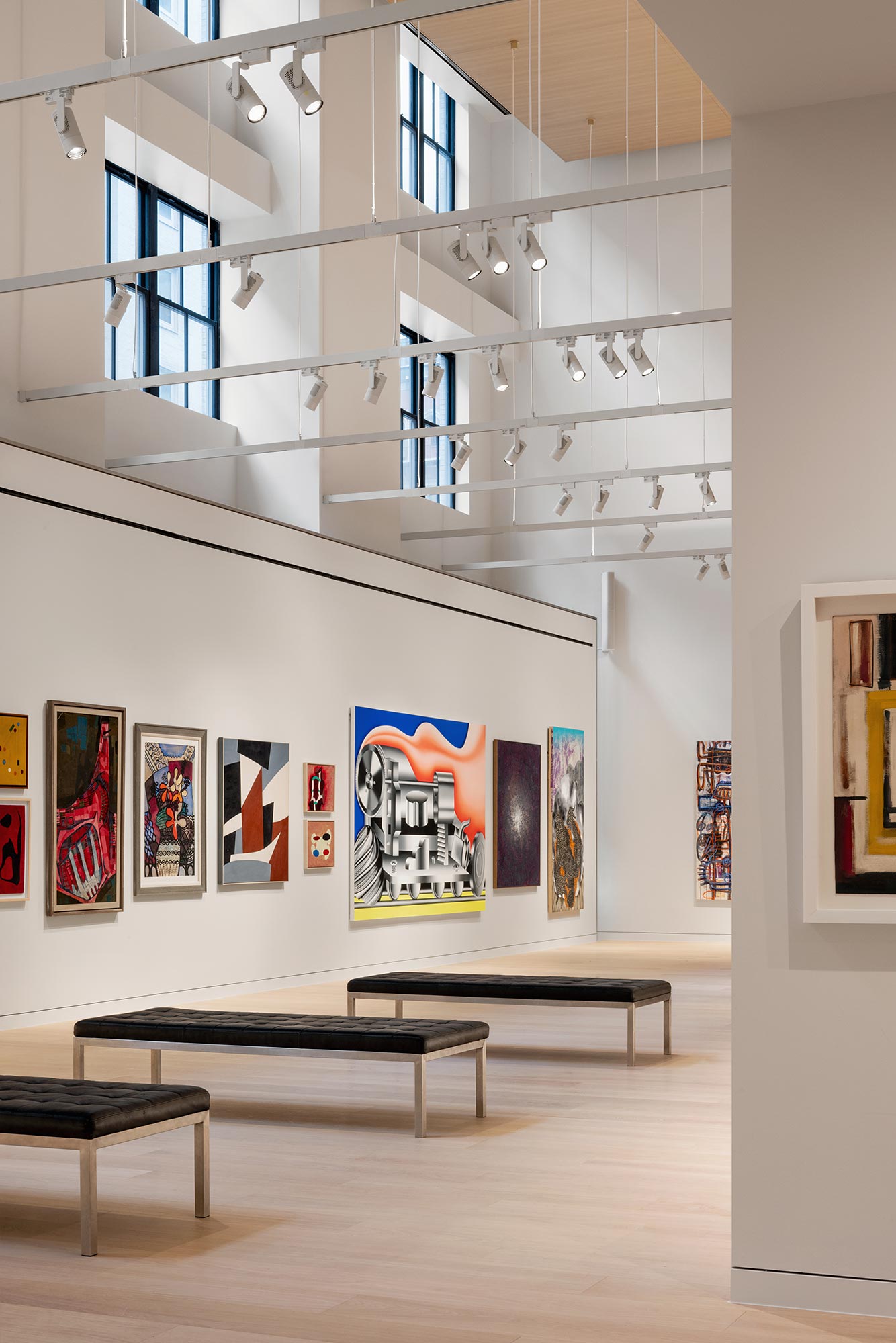 A room with benches and paintings on the wall.