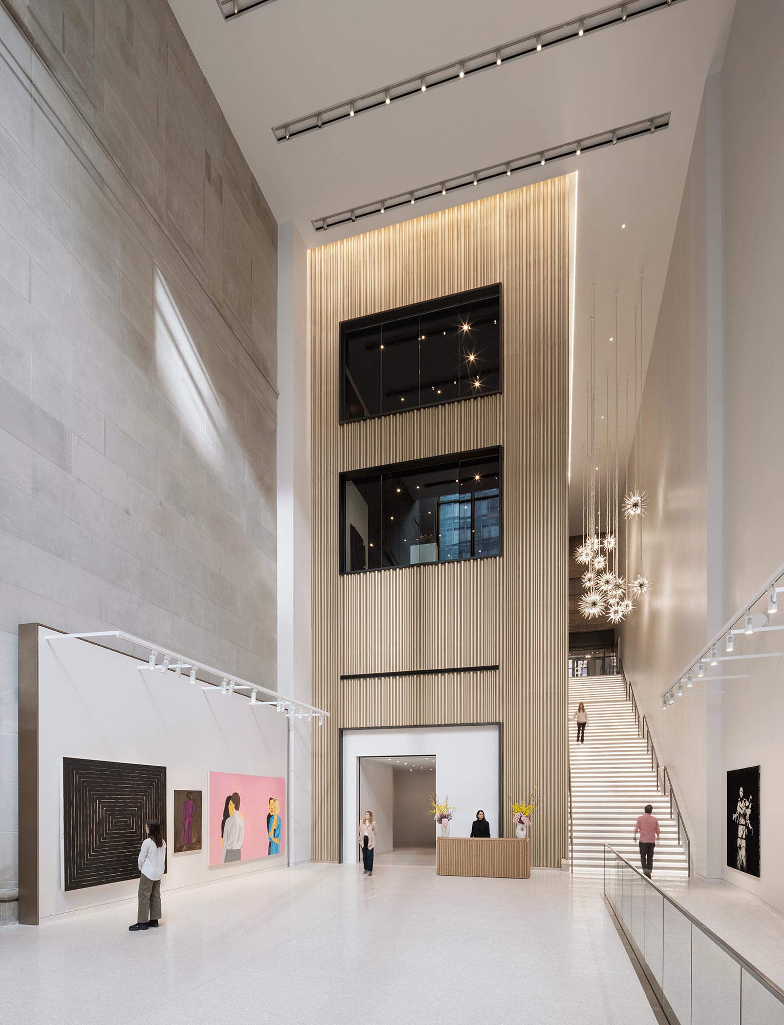 A room with a large staircase and a tv on the wall.