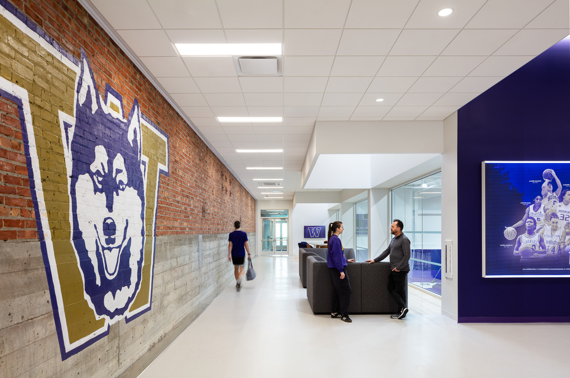 People in a room with a wall of art.