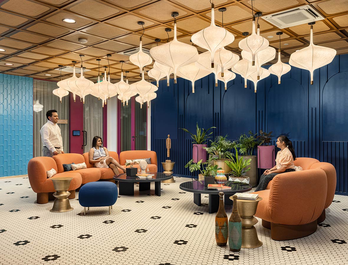 A group of people sitting in a room with a large ceiling.