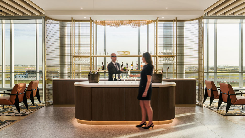 A woman standing in front of a counter with a man behind her.