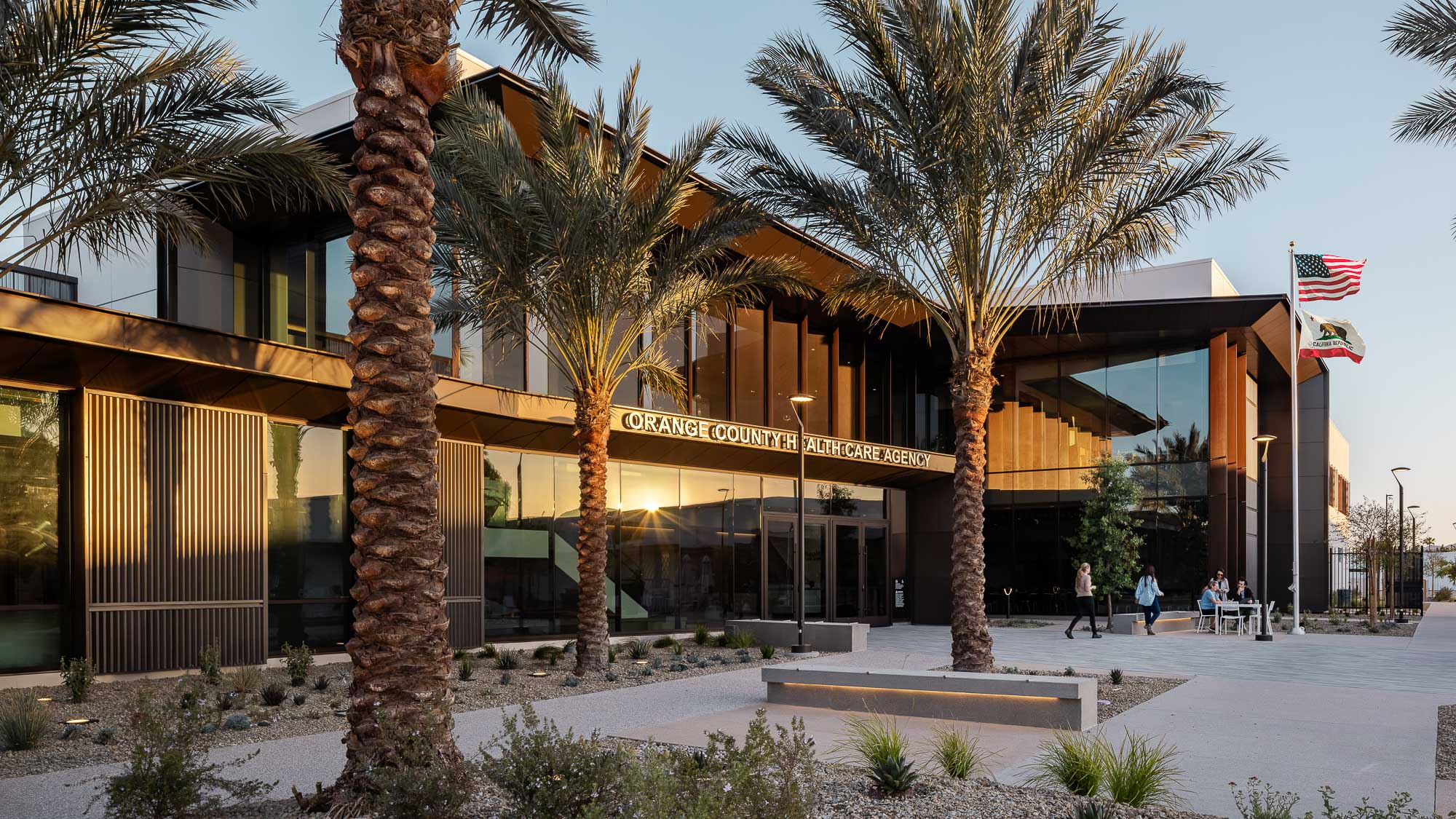 A building with palm trees and flags.