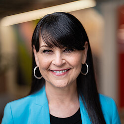 A woman with earrings smiling.