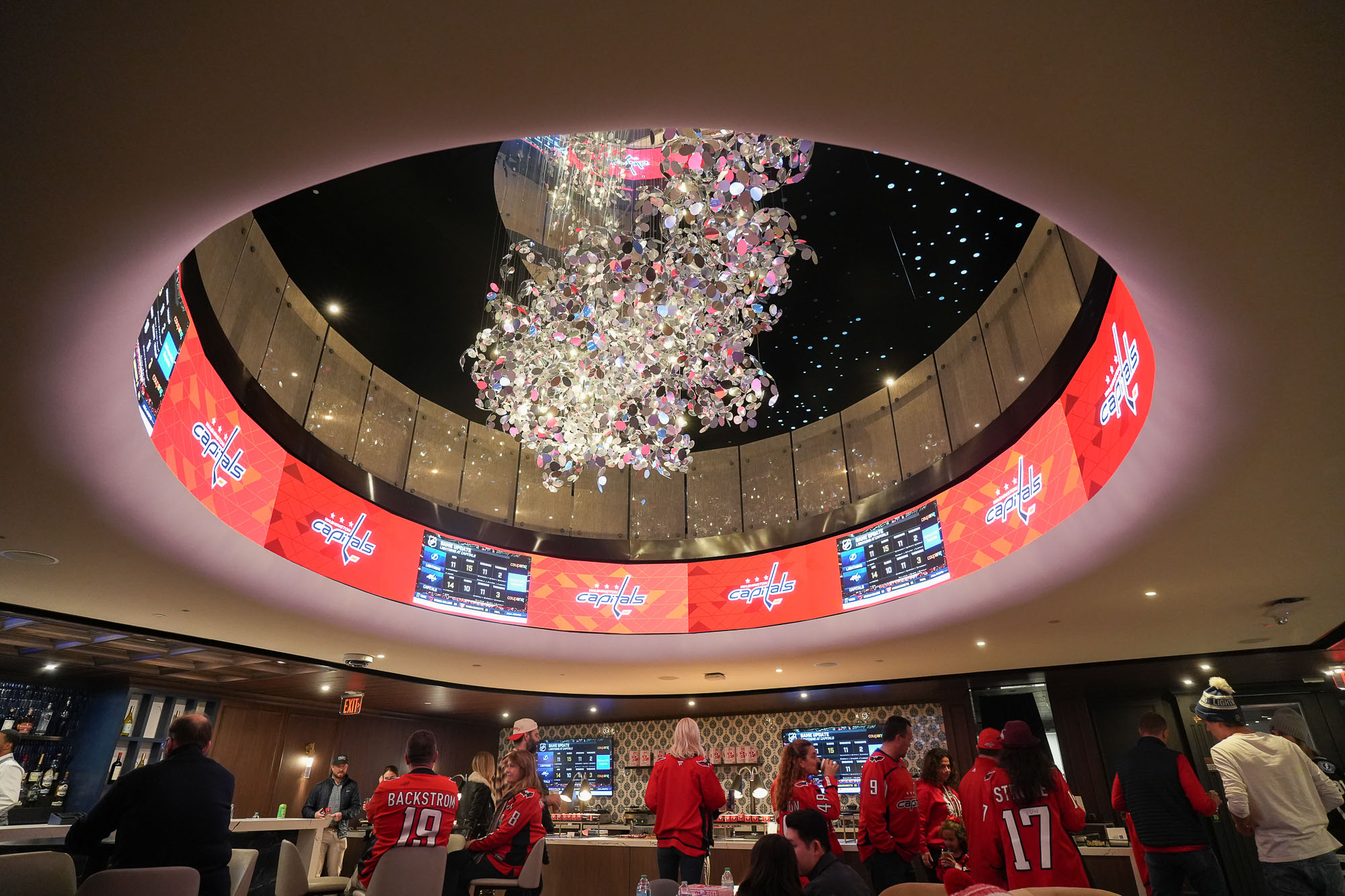 A group of people in a room with a large circular ceiling.