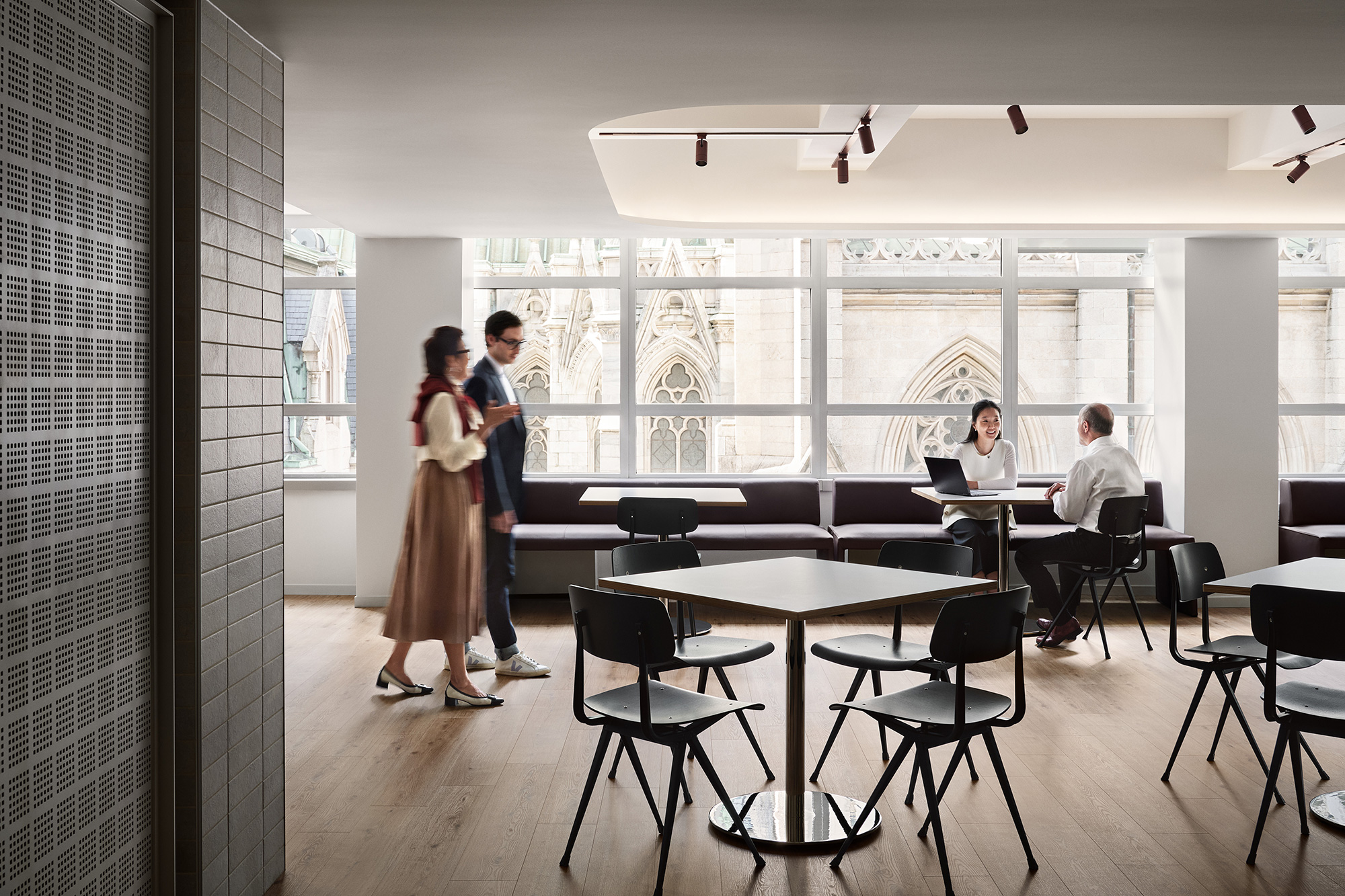 A man and woman standing in a room with a table and chairs.
